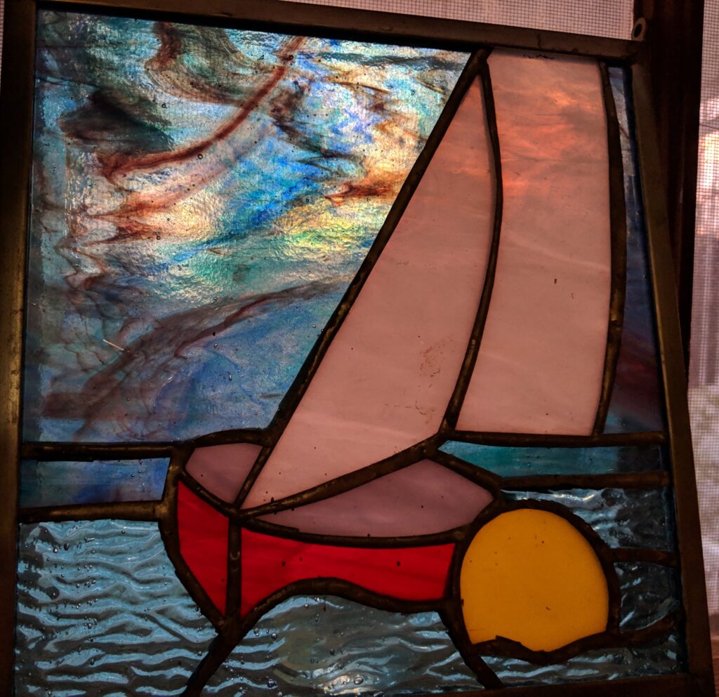 Stained glass sailboat by a windward mark.  Rounding the mark under threating clouds